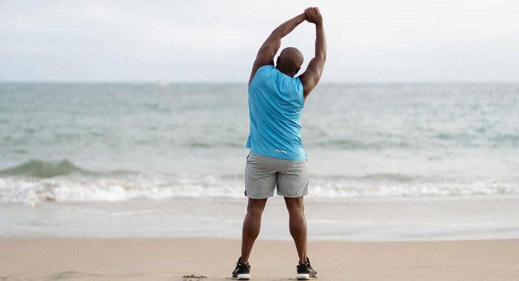 man stretching on beach